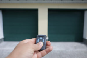 Man Holds In His Hand A Remote Control That Opens The Garage Door